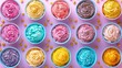   A collection of colorful cupcakes in blue bowls, set against a pink backdrop and adorned with golden sprinkles
