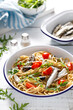 Whole grain pasta with sardines, tomato and arugula. Italian Sicilian cuisine.