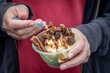 An indulgent dessert being eaten out of a plastic container, with a shallow depth of field
