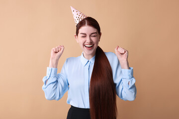 Canvas Print - Happy woman in party hat on beige background