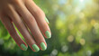 Mão de uma mulher com as unhas pintadas de verde claro