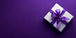 white gift box with purple ribbon on purple background