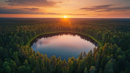 Wall Mural - Expansive sunset view over a circular lake surrounded by dense forest, showcasing the beauty of nature