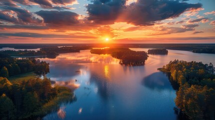 Wall Mural - The sun sets in a blaze of glory over a large lake dotted with islands and surrounded by forests