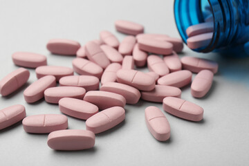 Sticker - Vitamin pills and bottle on grey background, closeup