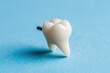 A single tooth on a blue surface. Suitable for dental or health concepts