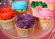 Delicious cupcakes with bright cream on pink table, closeup