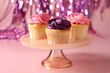 Delicious cupcakes with bright cream on pink background