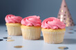 Delicious cupcakes with bright cream and confetti on light background, closeup