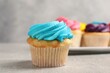 Delicious cupcakes with bright cream on gray table, selective focus