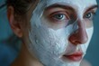Close-up of a young woman with a calming white face mask, showcasing her mesmerizing green eyes and advocating for skincare and well-being