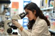 Determined young woman scientist performs analysis with a microscope in a contemporary laboratory, offering insight into the realm of scientific exploration and innovation