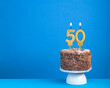 Birthday celebration with candle 50 - Chocolate cake on blue background