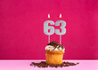 Birthday celebration with candle number 63 - Chocolate cupcake on pink background