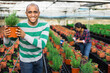 Portrait of confident male farmer engaged in cultivation of plants in greenhouse