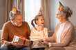 Grandparents Celebrating Their Granddaughters Birthday in a Cozy Living Room