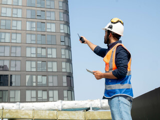 Male man person people backside pointing finger cheerful building city urban blue sky background copy space engineer construction work job manager plan strategy facility architecture foreman project 