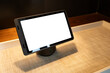 Mockup background of a tablet computer or digital electronic device with a blank white screen on a table. Empty bedside interactive touchpad with plug-in charging holes at the bottom.