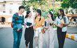 © photobyphotoboy - A group of young women are walking down the street, each carrying a book