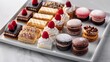 © Paul - Gourmet dessert platter featuring mini pastries and macarons, arranged elegantly, highlighted with professional studio lighting