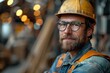 Portrait of mature male worker in hardhat and eyeglasses in factory