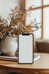 Poster - composition featuring a handphone mock-up placed on a table in a cozy room, with a white screen