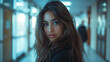 © NaphakStudio - A striking portrait of a young latin woman with flowing hair and a piercing gaze, standing in a softly lit hallway, creating a mood of anticipation.