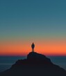 © Adobe Contributor - Man standing alone on a rock in front of the ocean at sunset