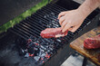 Unrecognizable man put raw steak on grill