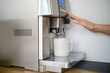 Hand presses coffee button in coffee machine