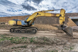 Fototapeta Uliczki - Excavator building a road in a site construction