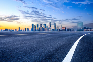 Empty asphalt road and modern city skyline background