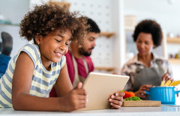 Wall Mural - Happy african american parents and child having fun preparing healthy food in kitchen