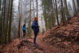 Fototapeta  - HIkers with backpacks on a trail in a rainy day