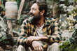 © simona - One happy and serene adult man sitting outdoor in the green nature garden. Copy space image of alternative male people having relax time alone enjoying silence and loneliness. Lifestyle concept