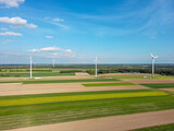 Fototapeta Storczyk - Spring farmlands and electric windmills.