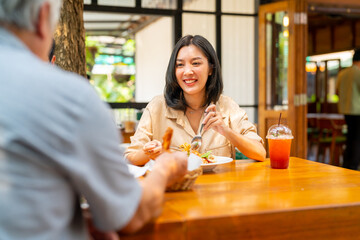 Wall Mural - Happy Asian family couple and senior father having lunch eating food together at cafe restaurant on summer holiday vacation. Family relationship, father's day and elderly people health care concept.