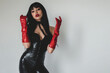 Beautiful adult woman wearing black spandex dress and long red leather gloves