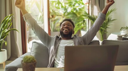 Successful businessman celebrating his success while sitting at his desk in office