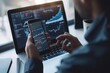 © ffunn - business, technology, internet and people concept - close up of man with laptop computer and smartphone with stock market chart on screen over office background