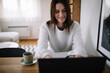 Smiling woman working from home using dining table as desk