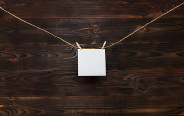 Sticker - paper card hanging on the rope on wooden background