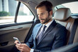 © Big - A man in a suit sits in the backseat of a car, looking at his phone. AI Generative