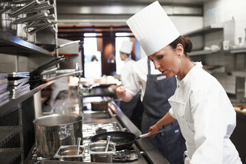 cooking, chef and woman in kitchen at restaurant for fine dining, service or hospitality industry. e