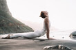 Woman is practicing yoga on the beach.