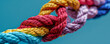 Colorful ropes tied in a knot on a blue background