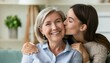 © ULFATRAZA - Happy loving adult daughter kissing cheerful laughing mature mum with love, gratitude