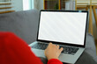 Cropped shot unrecognizable young woman using laptop on sofa. Empty screen for advertising