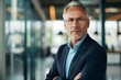 © willian - Portrait of a middle-aged businessman man demonstrating confidence and maturity in the business environment in luxurious corporate office.
