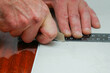 A man cuts a plastic pvc panel with a construction knife
